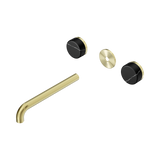 An image of Nero Tapware's Serenity Wall Basin Set 220mm Spout With Marquina Black Handle Trim Kit Only Brushed Gold